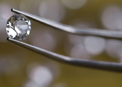 closeup tweezers holding diamond