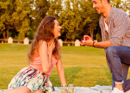 man proposing in park over picnic